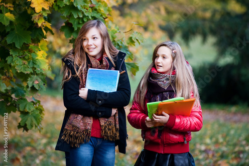 Schoolgirls with notebooks looking with interest
