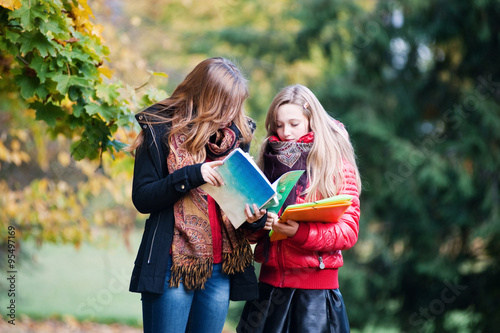 Schoolgirls looking into the notebook
