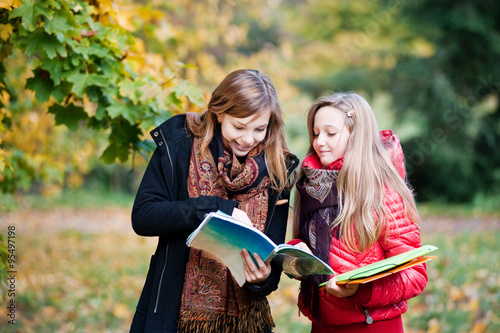 Schoolgirls with notebooks discussing the task