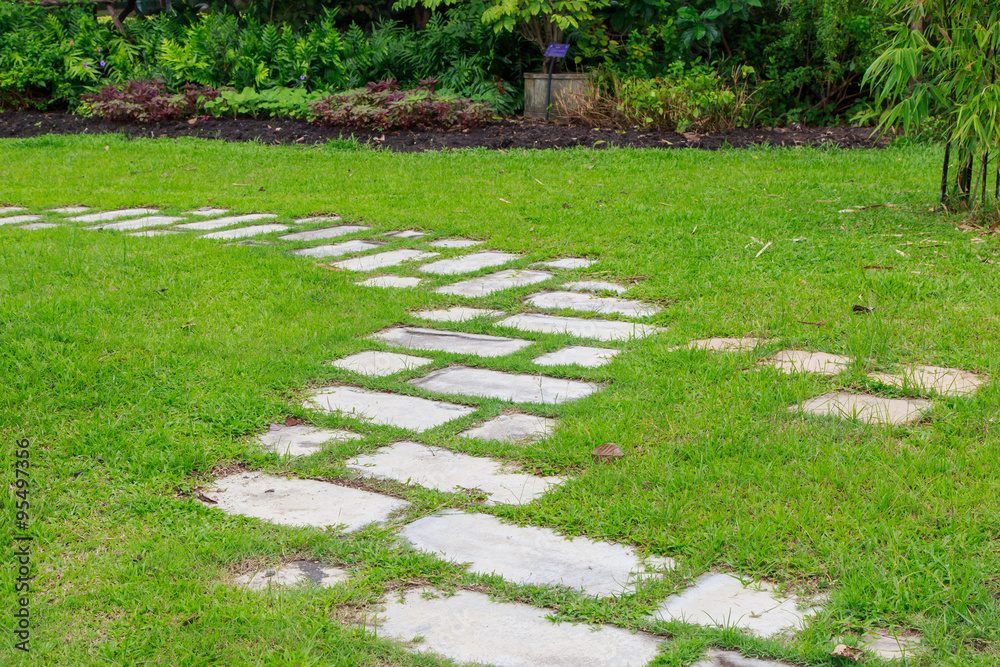 Stone walkway pattern on a grassy field perspective