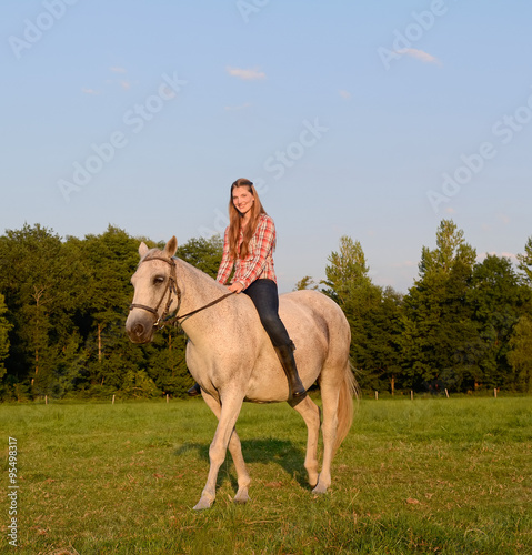 Junge Frau sitzt auf  Pferd © tunedin