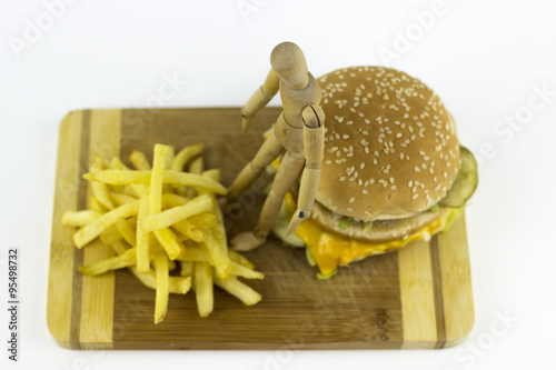 Wooden doll standing on a hamburger photo