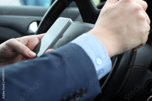 The businessman using mobile smart phone while driving the car © Saklakova