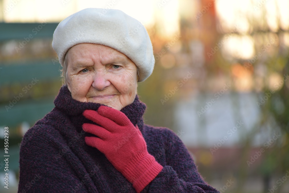Senior woman smiling and dreaming in garden.