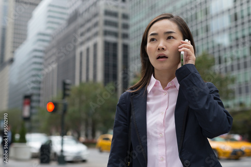 Asian business woman in New York City talking cell phone