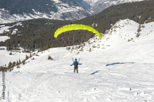 Paraglider taking off from a snowy slope