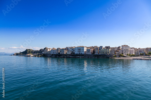 Corfu island cityscape from the sea with blue waters and sky.