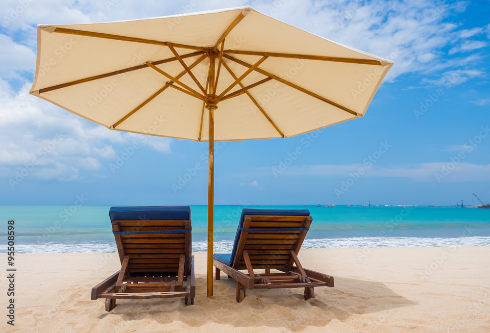 Beach chairs with umbrella and beach on a sunny day