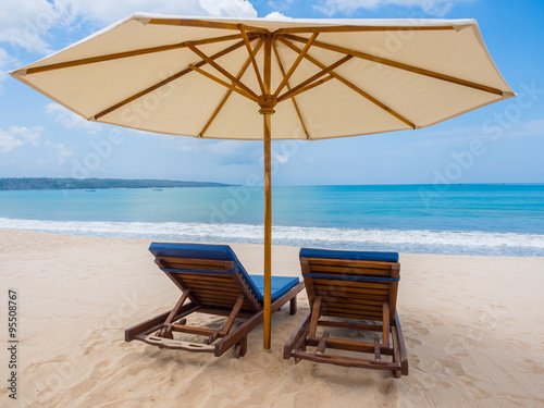 Fototapeta Naklejka Na Ścianę i Meble -  Beach chairs with umbrella and beach on a sunny day