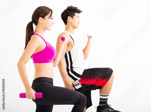 Young happy couple exercising with dumbbell