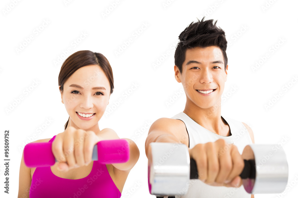 Young happy couple exercising with dumbbell Young happy couple exercising with dumbbell