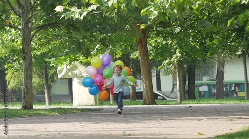 little girl runs with multicolored balloons, Slow motion photo