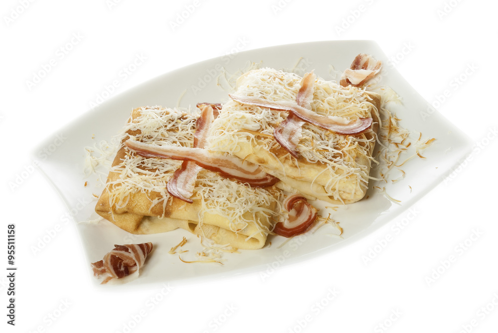 Two pancakes with savory filling served on a white plate with  bacon and grated smoked cheese. Isolated on white.