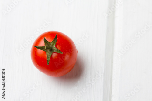 Red tomato on wooden white table