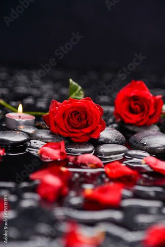 Red rose with petals with candle and therapy stones 