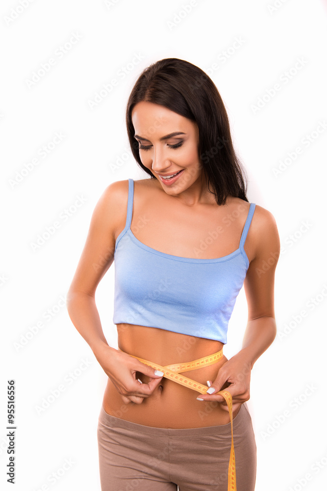 Slim beautiful girl measures the waist with a measuring tape Slim beautiful girl measures the waist with a measuring tape