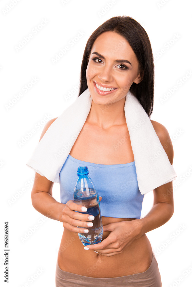 Slim pretty girl with towel holding a bottle with water Slim pretty girl with towel holding a bottle with water