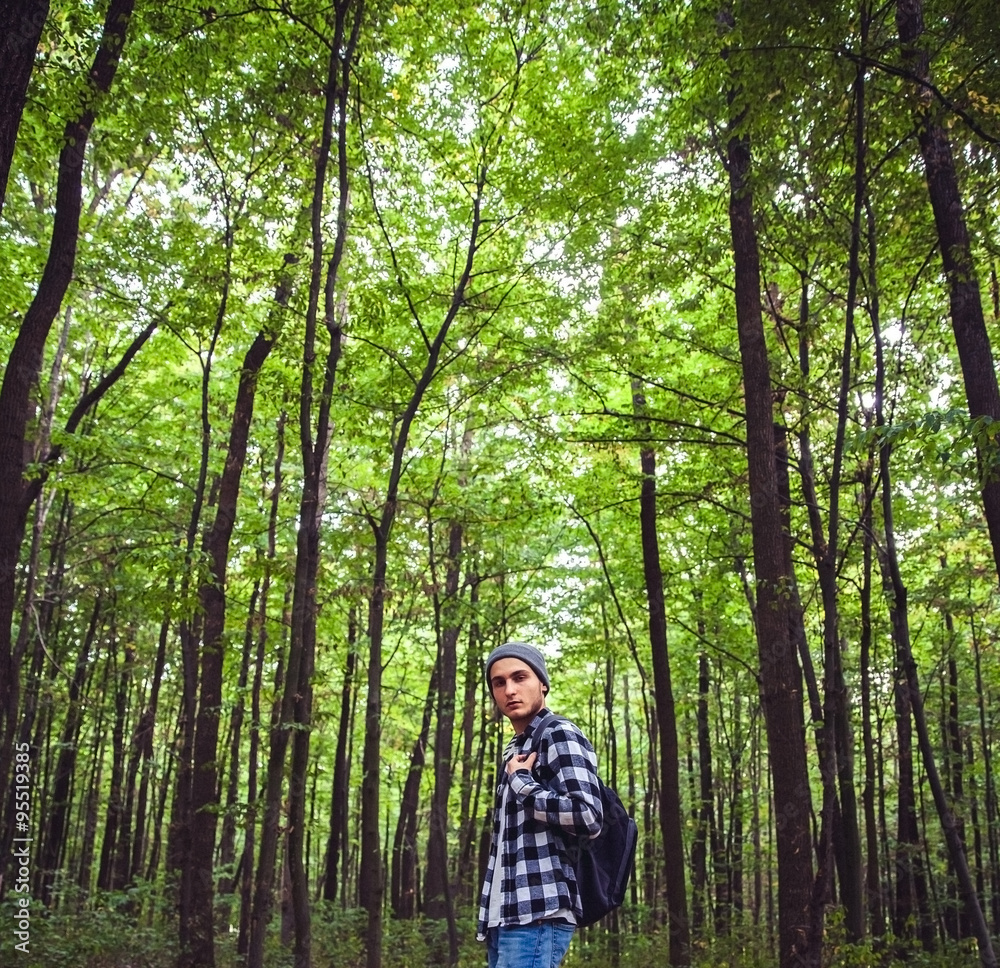 Portrait of young handsome man with backpack wanderer walk in the woods Portrait of young handsome man with backpack wanderer walk in the woods
