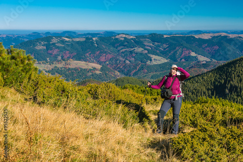 Woman Staying on Grassy Meadow in Mountain Landscape