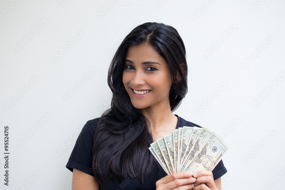 Closeup portrait, excited successful young business woman in black shirt holding money dollar bills in hand isolated white wall background. Positive emotion facial expression feeling. Financial reward Closeup portrait, excited successful young business woman in black shirt holding money dollar bills in hand isolated white wall background. Positive emotion facial expression feeling. Financial reward