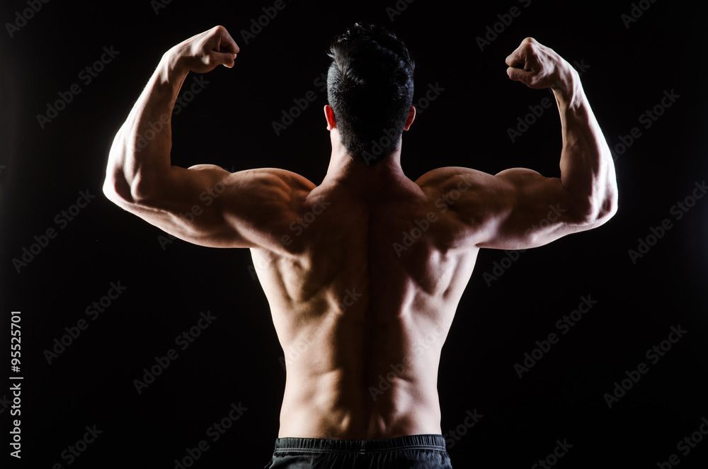 Muscular man posing in dark studio Muscular man posing in dark studio
