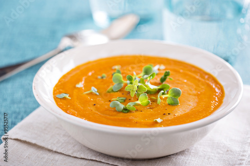 Curried carrot soup with cream and herbs photo
