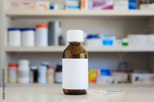 Blank white label of medicine bottle with blur shelves of drug i