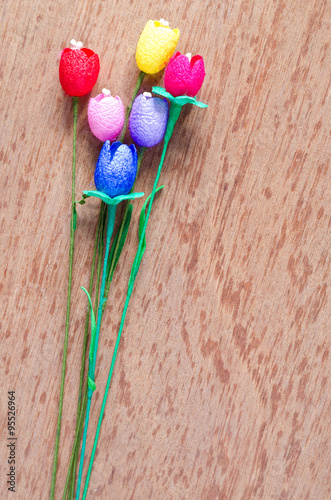 colorful artificial tulips flower made from silk cocoon on plywo
