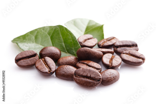 Close up coffee grains and leaves on white background