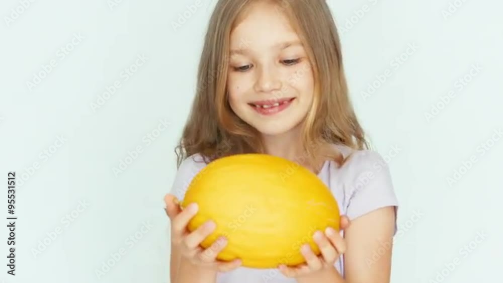 Girl sniffing melon and showing berry and laughing at camera. Closeup Girl sniffing melon and showing berry and laughing at camera. Closeup