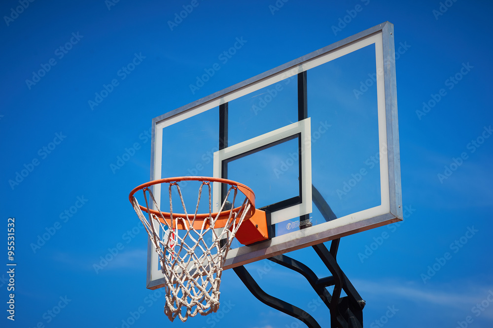 Basketball hoop in blue sky.