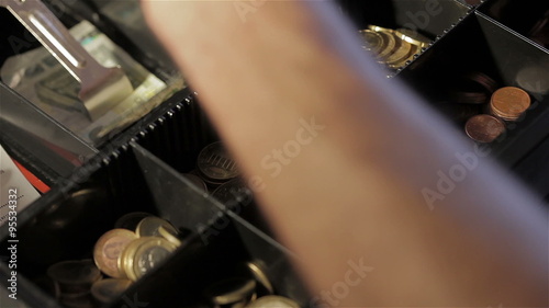 Man at cash drawer taking coins