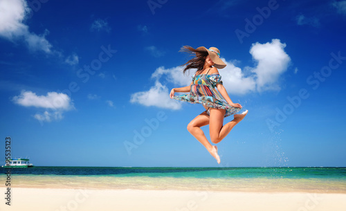 Carefree young woman is jumping into the sky
