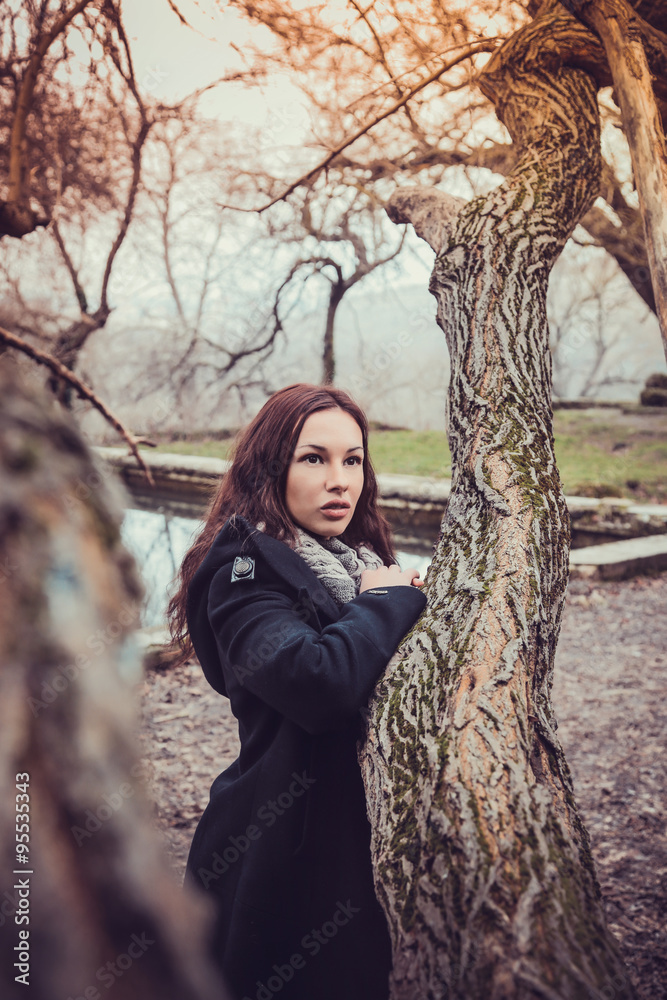 Fashion woman walking in dark autumn park Fashion woman walking in dark autumn park