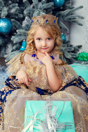 pretty little girl near the new year tree. beautiful girl in dress near Christmas tree waiting for holiday. little Princess © selenit