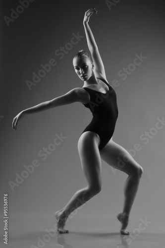 Modern ballet dancer posing on dark background © Demian