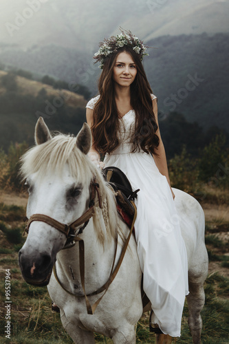 beautiful fabulous happy  bride riding a horse on the background