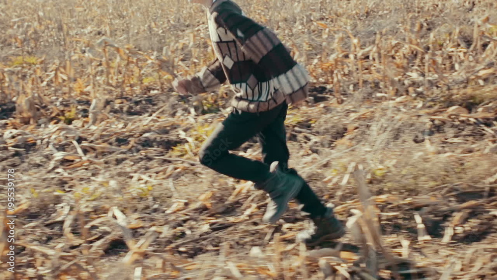 Country boy running on the mown corn field Country boy running on the mown corn field