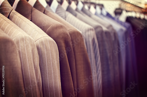 Men suits hanging in a clothing store.