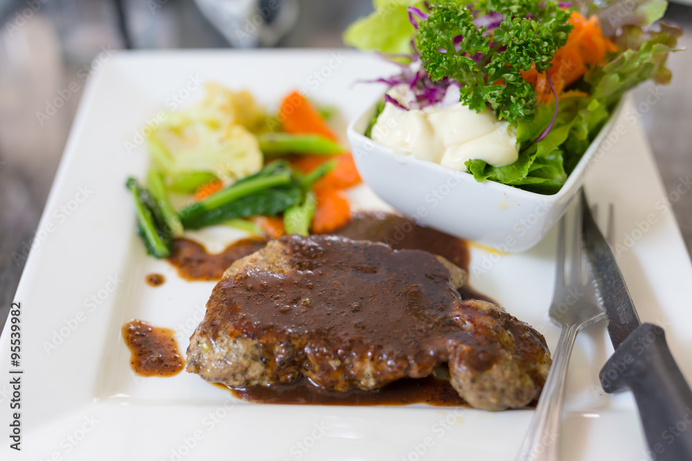 A dish of meat steak covered with herb