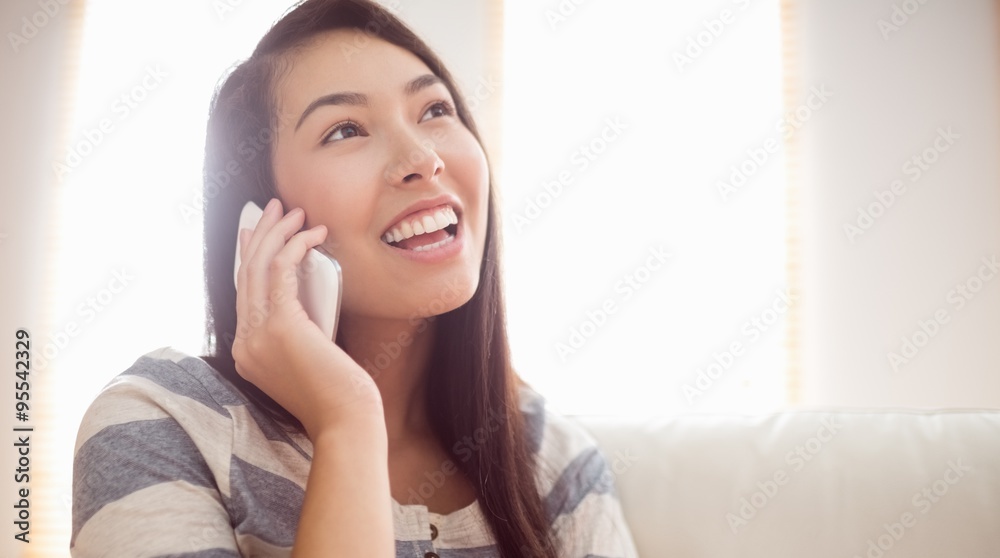 Smiling asian woman on couch using phone Smiling asian woman on couch using phone