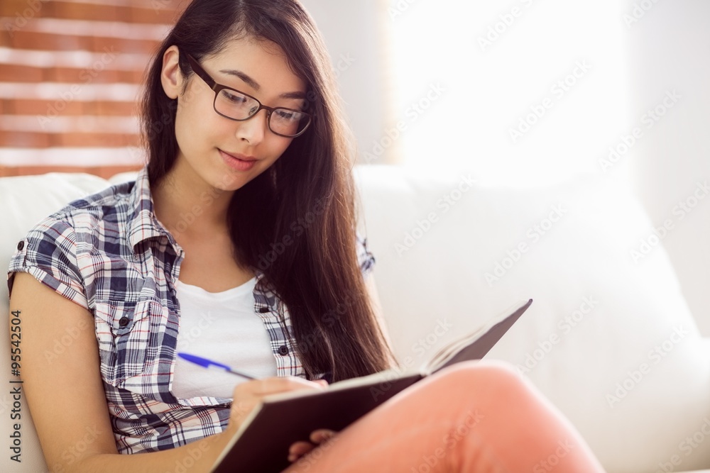 Asian woman on the couch writing 