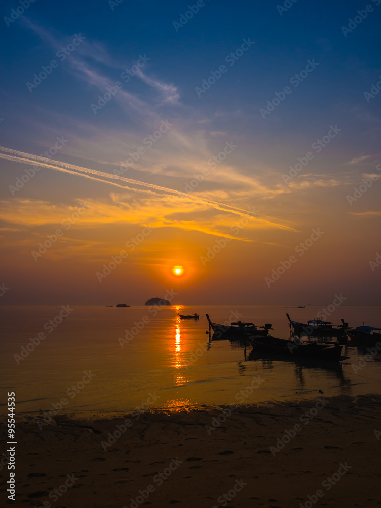 Beautiful Sunrise and silhouette local fishing boats on sea at t