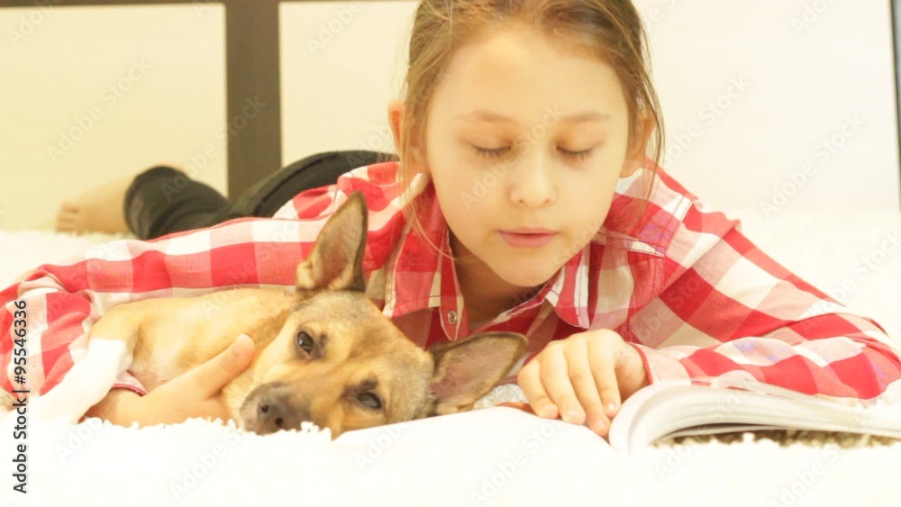 kid and dog reading a book lying on the couch kid and dog reading a book lying on the couch