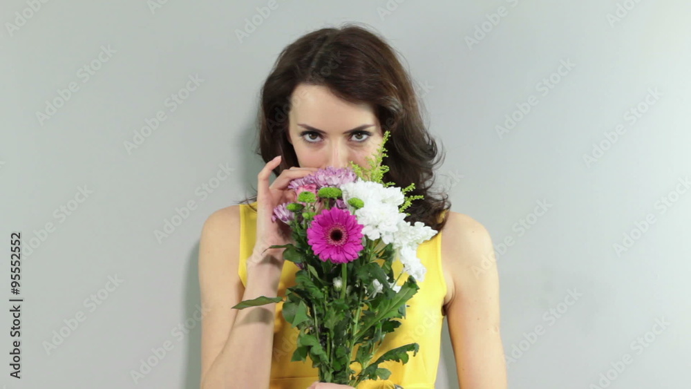 Young woman holding a bouquet of flowers smiling Young woman holding a bouquet of flowers smiling