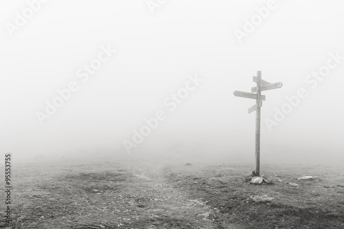 wooden signpost in the fog