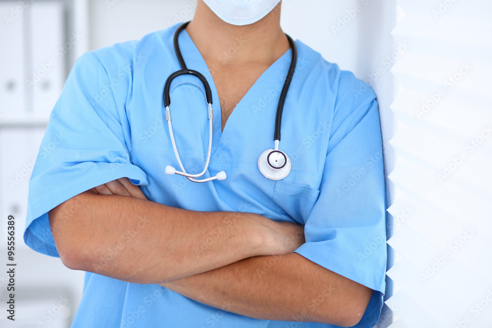 Portrait of unknown male surgeon doctor standing near the wall  in hospital office