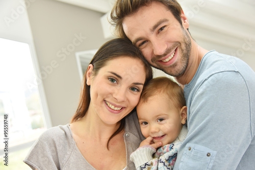 Portrait of happy parents holding baby girl