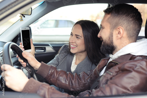 couple looking at smartphone in a car