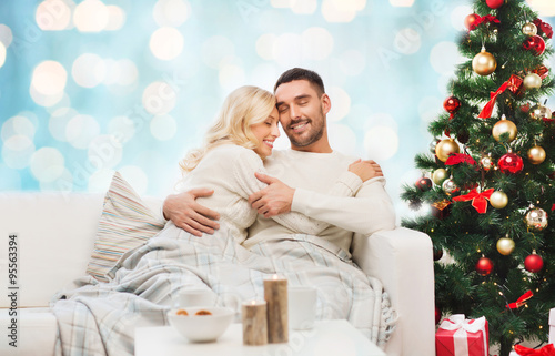 happy couple hugging on couch at christmas © Syda Productions